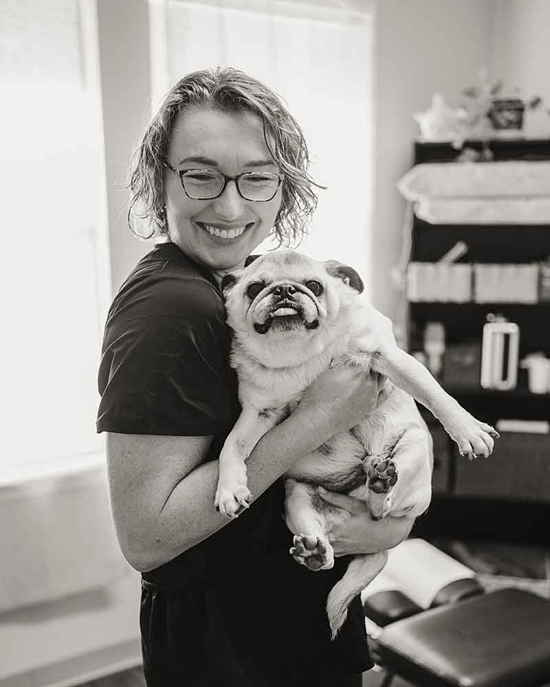 Photo from Central Texas Animal Chiropractor of Dr Amanda Massey holding a dog she has just adjusted.